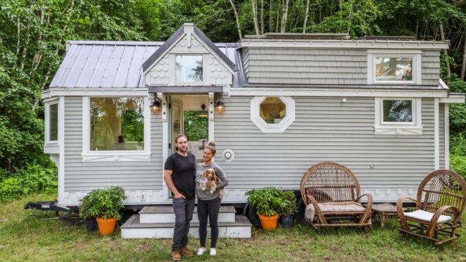couple standing in front of tiny house